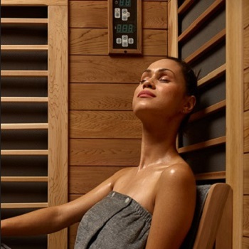 Woman Sweating in Infrared Sauna in Towel